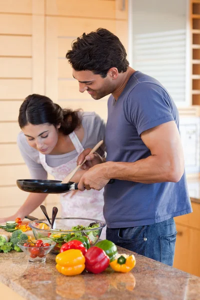 一对年轻夫妇用一个平底锅烹饪的肖像 — 图库照片