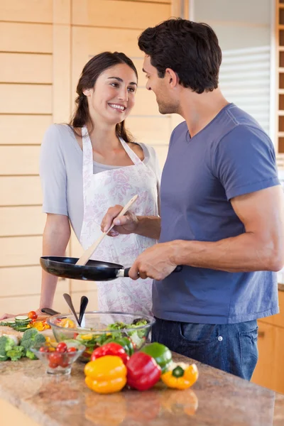 Portrait of a beautiful couple cooking with a pan — Stock Photo, Image