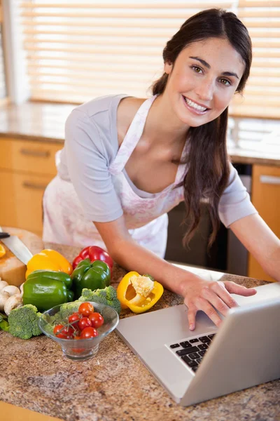 Portrait of a young woman looking for a recipe on the internet — Stock Photo, Image