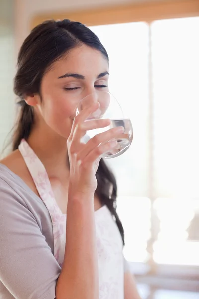 Retrato de uma mulher sorridente bebendo água — Fotografia de Stock