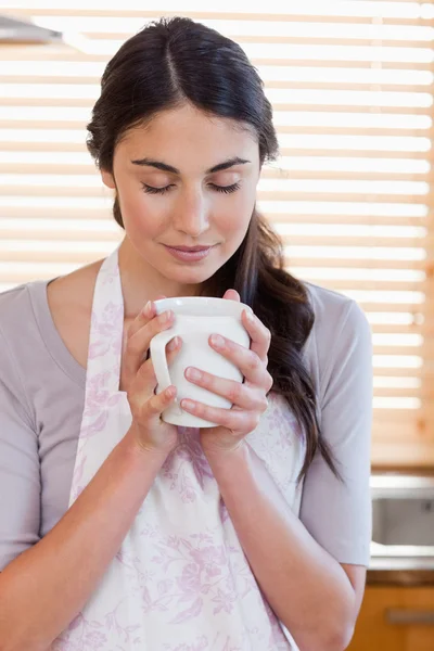 Portrait of a woman smelling a cup of coffee — Stock Photo, Image