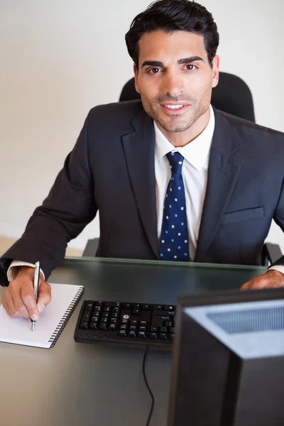 Portrait of a handsome businessman taking notes — Stock Photo, Image