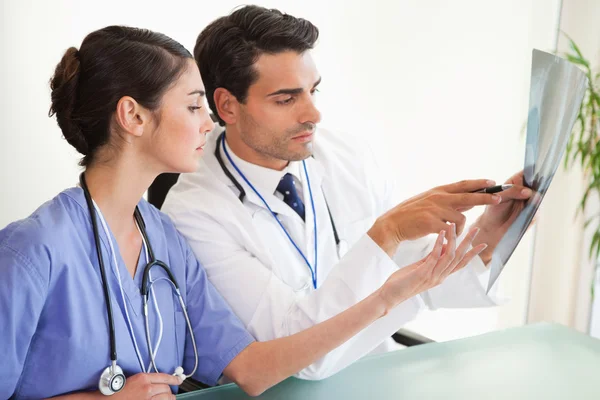 Serious doctors looking at a set of X-ray — Stock Photo, Image