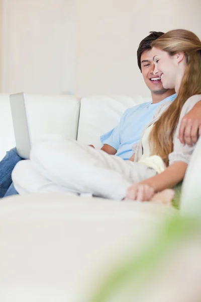 Retrato de um jovem casal usando um laptop — Fotografia de Stock
