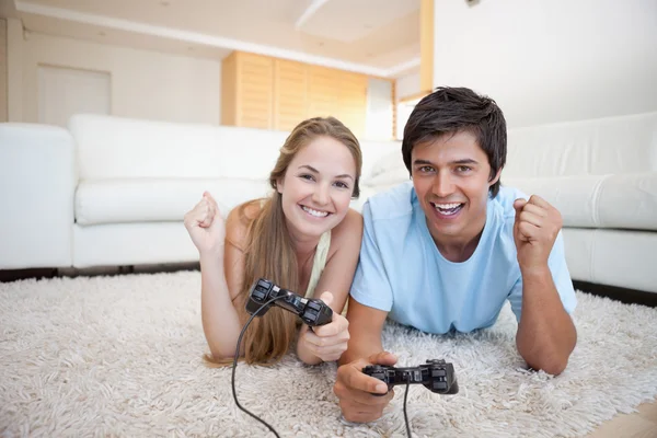 Веселая молодая пара, играющая в видеоигры — стоковое фото