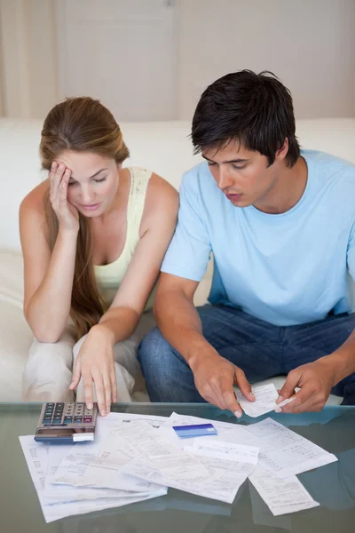 Portrait of a worried couple looking at their bills — Stock Photo, Image