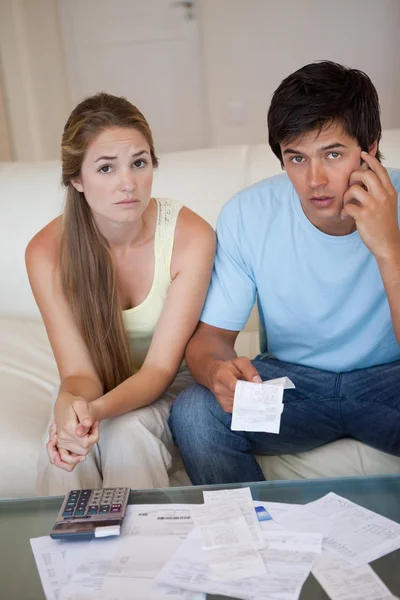 Portrait of a worried couple looking at their receipts — Stock Photo, Image