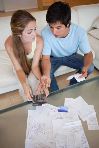 Portrait of a sad couple looking at their receipts — Stock Photo, Image