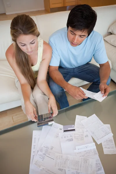 Portrait d'un jeune couple regardant leurs factures — Photo