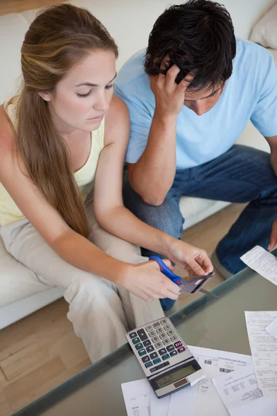 Retrato de um casal cortando seu cartão de crédito — Fotografia de Stock