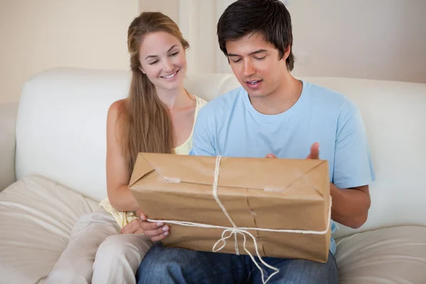Young couple looking at a package — Φωτογραφία Αρχείου