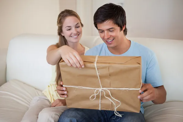 Couple opening a package — Stockfoto