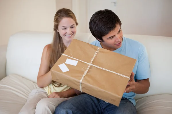 Посміхнена пара відкриває пакет — стокове фото
