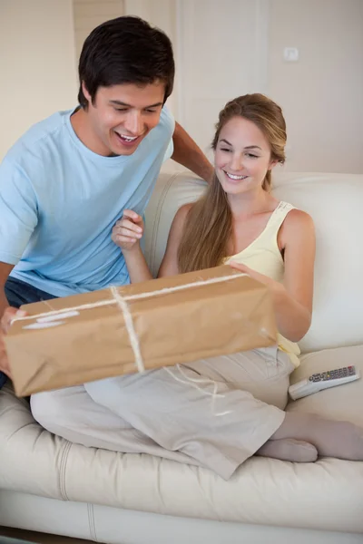 Retrato de una pareja mirando un paquete — Foto de Stock