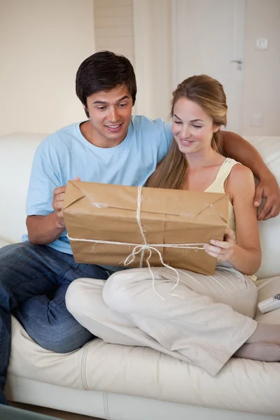 Retrato de um jovem casal olhando para um pacote — Fotografia de Stock