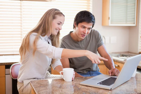 Lachende paar hebben koffie tijdens het gebruik van een laptop — Stockfoto