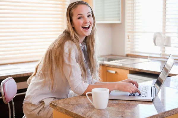 Kadın bir dizüstü bilgisayar kullanırken çay içiyor — Stok fotoğraf