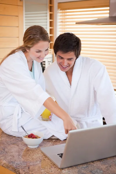 Porträt eines schönen Paares beim Frühstück mit einem Lapto — Stockfoto