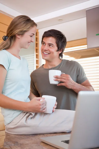 Porträtt av ett ungt par att ha kaffe medan du använder en bärbar dator — Stockfoto