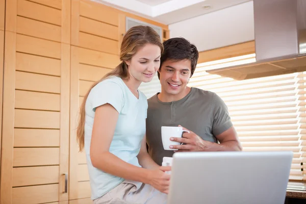 Paar hebben thee tijdens het gebruik van een laptop — Stockfoto