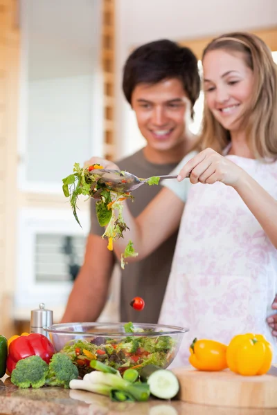 Porträt eines charmanten Paares, das einen Salat zubereitet — Stockfoto