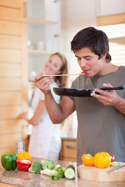 Portret mężczyzny, gotowania, podczas gdy jego dziewczyna jest mycie di — Zdjęcie stockowe