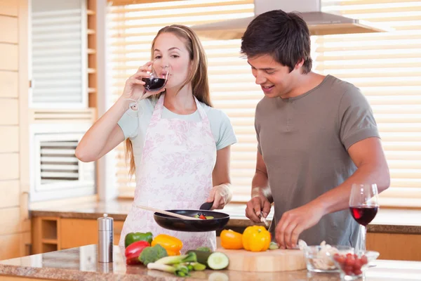 Casal cozinhar jantar enquanto bebe vinho — Fotografia de Stock