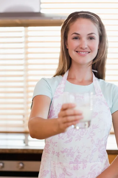 Portret van een jonge vrouw geven een glas melk — Stockfoto