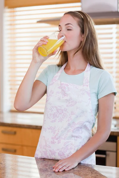 Retrato de uma bela mulher bebendo suco de laranja — Fotografia de Stock