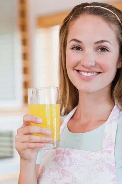 Retrato de una hermosa mujer bebiendo jugo de naranja — Foto de Stock