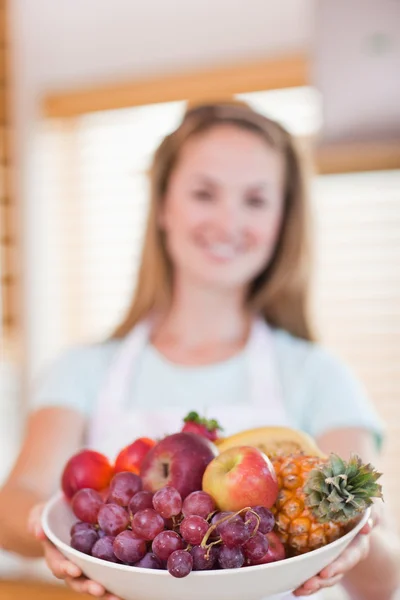 Portrait d'une jeune femme présentant un panier de fruits — Photo