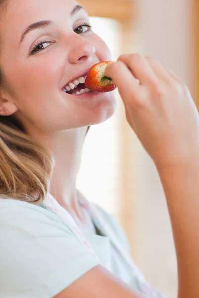 Nahaufnahme einer jungen Frau, die eine Erdbeere isst — Stockfoto