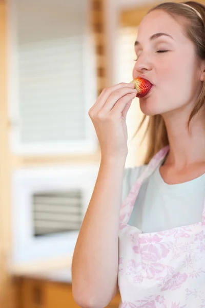 Retrato de uma mulher comendo um morango — Fotografia de Stock