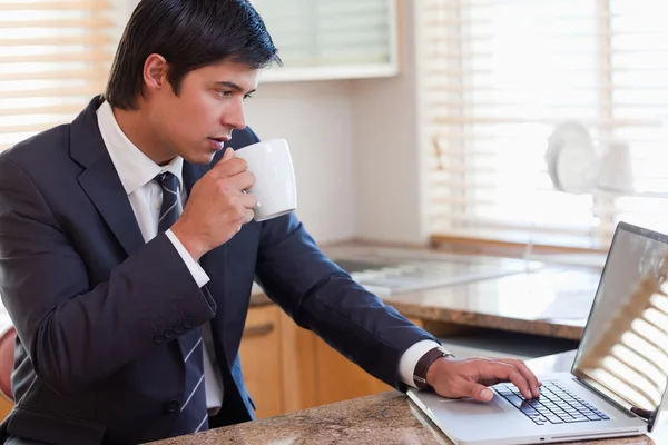 Hombre trabajando con un cuaderno mientras bebe té —  Fotos de Stock