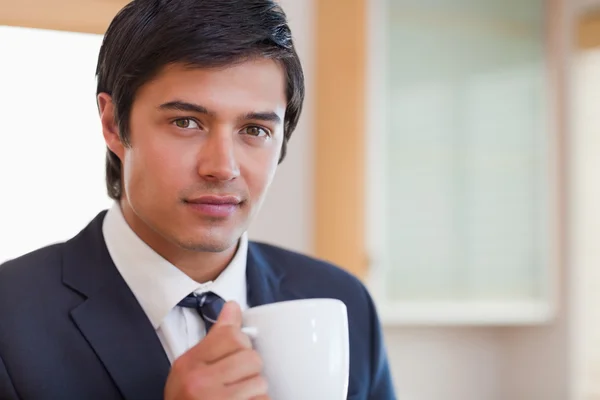 Primer plano de un hombre de negocios guapo bebiendo café — Foto de Stock