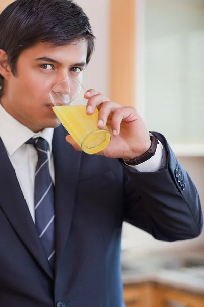 Retrato de um homem de negócios bebendo suco de laranja — Fotografia de Stock