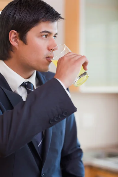 一个年轻的商人喝橙汁的肖像 — 图库照片