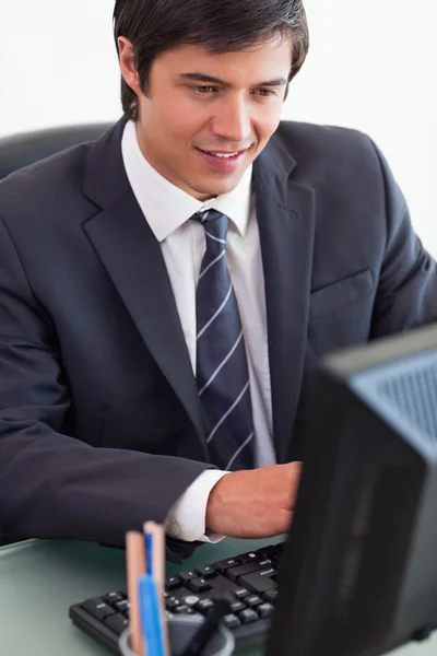 Porträtt av en ung affärsman som arbetar med en dator — Stockfoto