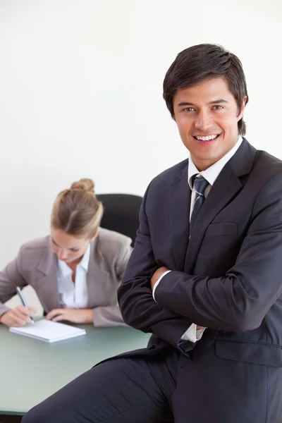 Porträt eines Büroangestellten, der posiert, während sein Kollege arbeitet — Stockfoto