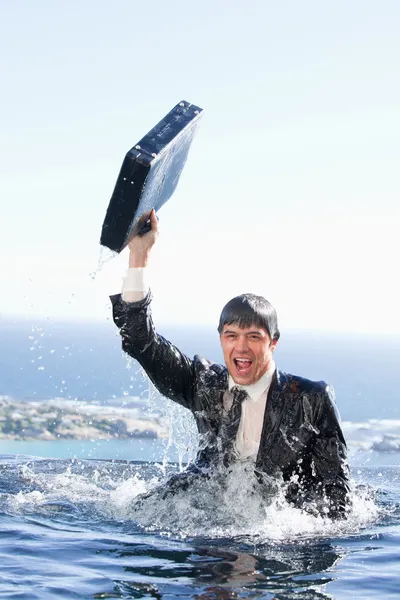 Portrait of a young businessman going out of the water with a br — Stock Photo, Image