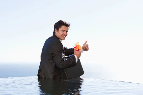 Retrato de um homem de negócios posando com um coquetel e uma pasta — Fotografia de Stock