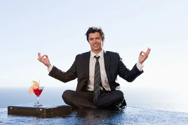 Smiling businessman relaxing in the lotus position — Stock Photo, Image