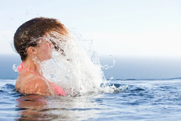 Молодая женщина поднимает голову из воды — стоковое фото