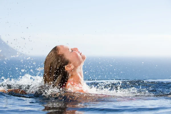 Великолепная женщина поднимает голову из воды — стоковое фото