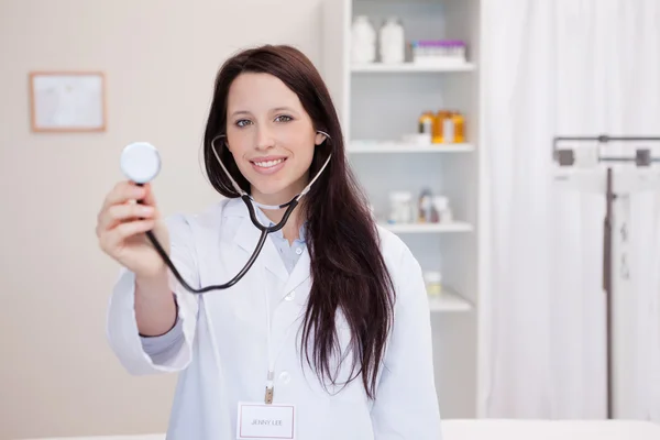 Lachende vrouwelijke arts met behulp van stethoscoop — Stockfoto