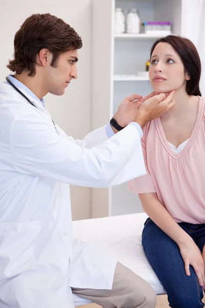 Male doctor examining his patients jaw — Stock Photo, Image