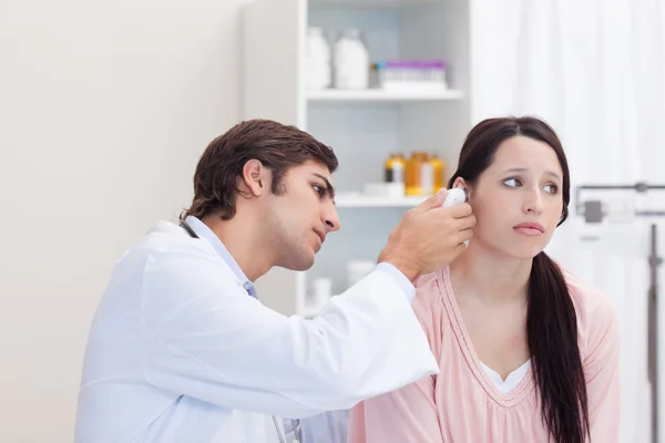 Male doctor examining his patients ear — Stock Photo, Image