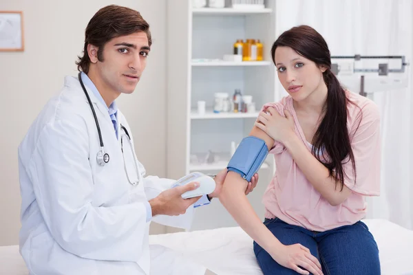 Médico tomando pacientes femeninos presión arterial — Foto de Stock