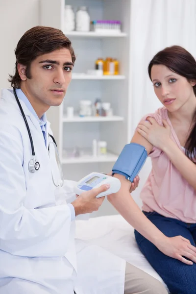 Médico examinando pacientes presión arterial — Foto de Stock