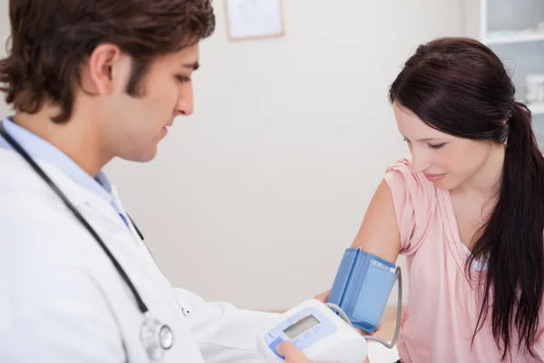 Manliga läkare tar kvinnliga patienter blodtryck — Stockfoto